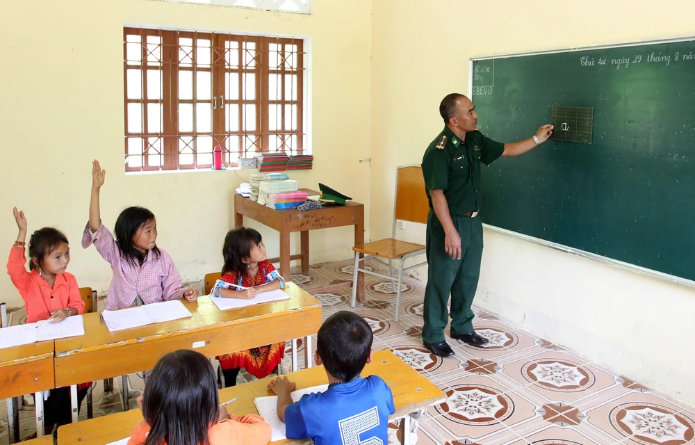 Thầy giáo quân hàm xanh thuộc đồn biên phòng A Mú Sung, huyện Bát Xát, Lào Cai dạy học cho các em học sinh tại điểm trường Phù Lao Chải. (Ảnh minh họa: Quốc Khánh/TTXVN)