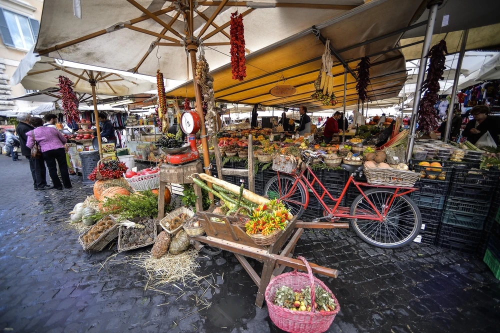 Người dân mua sắm tại một khu chợ ở Rome, Italy. (Ảnh: AFP/TTXVN)