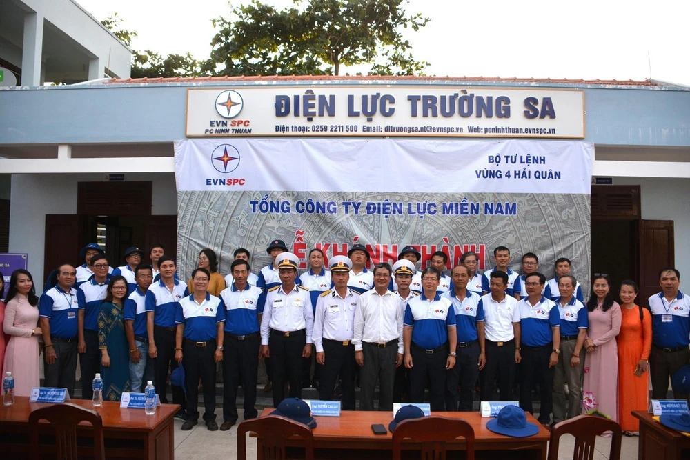 Đoàn công tác Tập đoàn Điện lực Việt Nam chụp ảnh lưu niệm trước trụ sở, văn phòng làm việc Điện lực Trường Sa. (Ảnh: TTXVN phát)