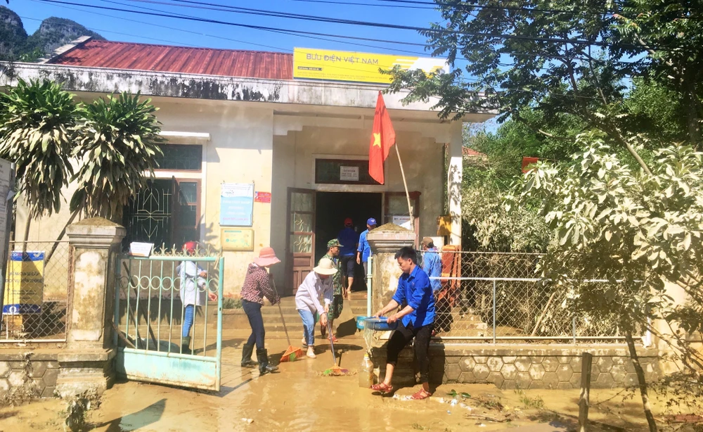 Các đoàn viên thanh niên hỗ trợ lau chùi bùn đất sau mưa lũ tại điểm bưu điện xã Tân Hóa, huyện Minh Hóa, tỉnh Quảng Bình. (Ảnh: Võ Dung/TTXVN)