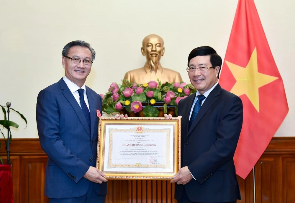 Bộ trưởng Bộ Ngoại giao Phạm Bình Minh trao Huân chương Lao động cho Đại sứ Lào tại Việt Nam Thongsavanh Phomvihane. (Ảnh: TTXVN)