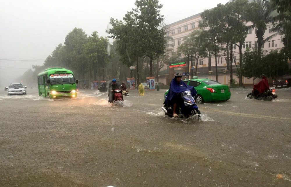 Nhiều tuyến đường thành phố Vinh bị ngập sâu khiến các phương tiện tham gia giao thông gặp nhiều khó khăn trong trận mưa sáng 16/10. (Ảnh: Tá Chuyên/TTXVN)