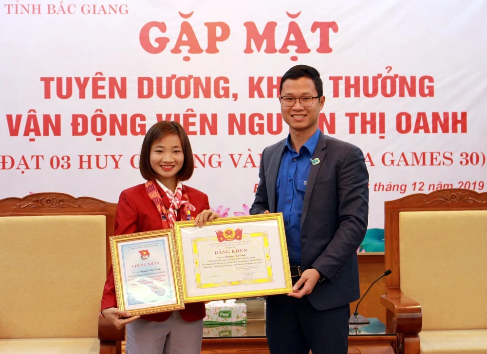 Đại diện Tỉnh đoàn Bắc Giang trao tặng bằng khen cho vận động viên Nguyễn Thị Oanh. (Ảnh: Đồng Thúy/TTXVN)
