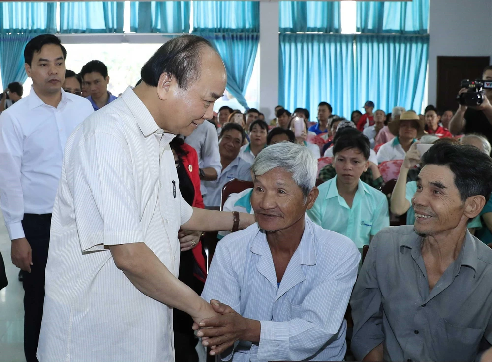 Thủ tướng Nguyễn Xuân Phúc thăm hỏi, động viên các đối tượng chính sách tỉnh Vĩnh Long. (Ảnh: Thống Nhất/TTXVN)