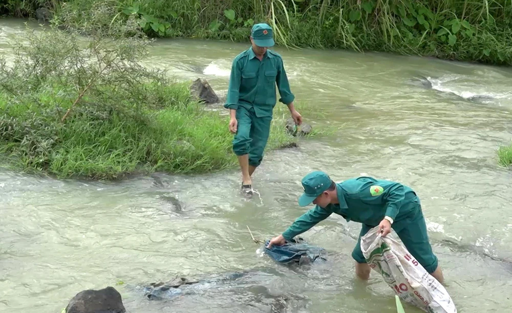 Dân quân tự vệ huyện miền núi Ngọc Lặc, tỉnh Thanh Hóa xuống sông, suối thu gom rác thải để hạn chế ô nhiễm môi trường. (Ảnh: Nguyễn Nam/TTXVN)