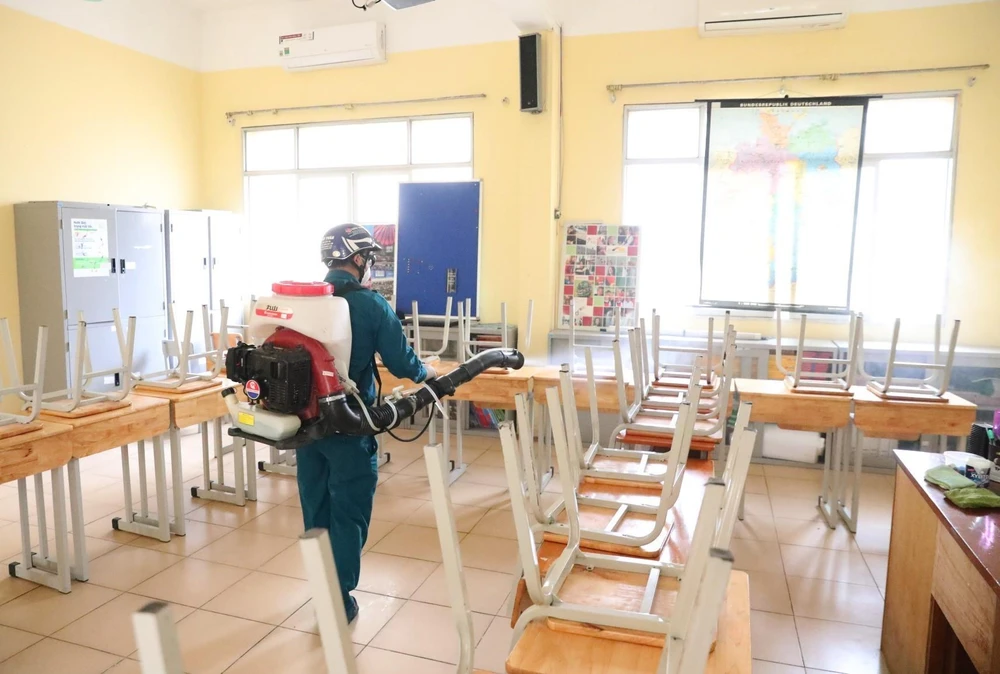 Nhân viên y tế quận Hoàn Kiếm phun thuốc khử trùng các phòng học trường THPT Việt Đức (ảnh chụp chiều 2/2/2020). (Ảnh: Thành Đạt/TTXVN)