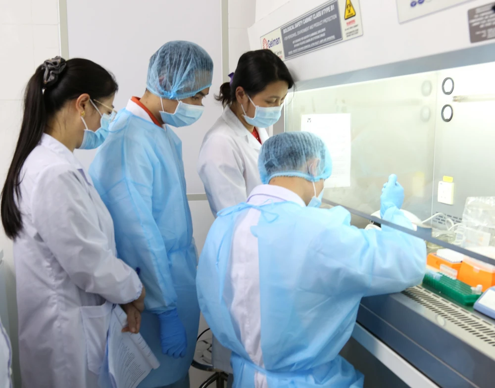 Cán bộ các tỉnh phía Bắc thực hành tại phòng tách chiết mẫu bệnh phẩm, Trung tâm kiểm soát bệnh tật tỉnh Yên Bái. (Ảnh: Đức Tưởng/TTXVN)