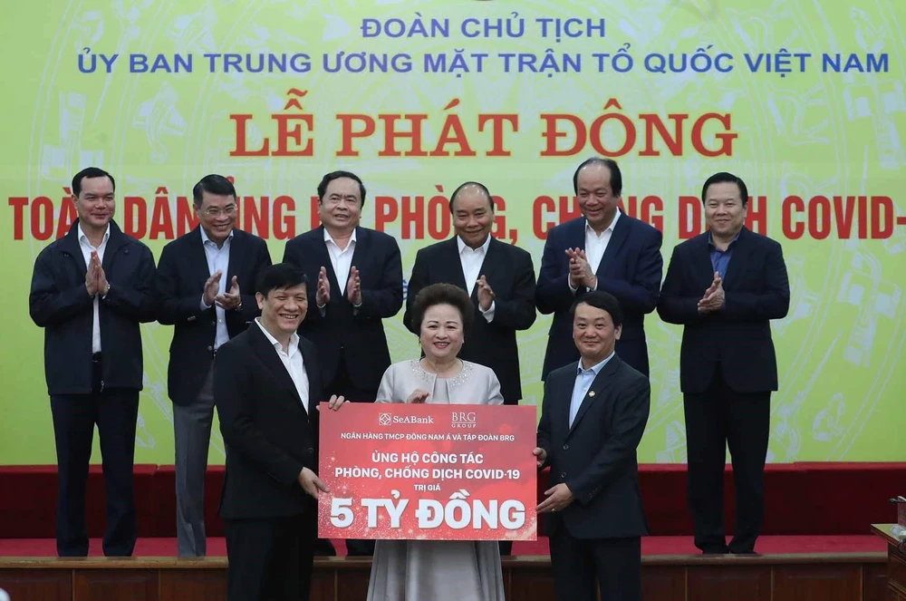 Thủ tướng Nguyễn Xuân Phúc cùng các đại biểu chứng kiến các tổ chức và cá nhân quyên góp ủng hộ công tác phòng, chống dịch COVID-19. (Ảnh: Thống Nhất/TTXVN)