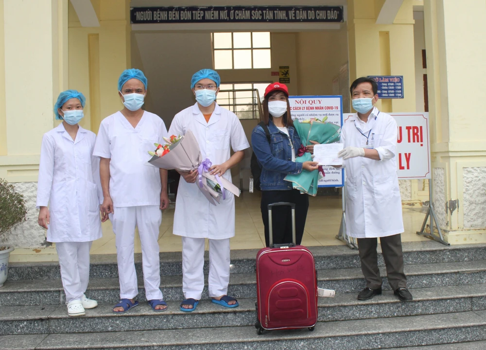 Giám đốc Bệnh viện Đa khoa huyện Nho Quan tặng hoa cho bệnh nhân 229 trong ngày xuất viện. (Ảnh: Thùy Dung/TTXVN)