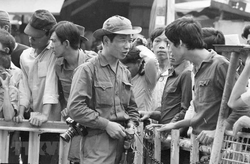 Phóng viên Đinh Quang Thành của Việt Nam Thông tấn xã gặp gỡ, thu thập thông tin từ người dân Sài Gòn trong ngày giải phóng, 30/4/1975. (Ảnh: TTXVN)