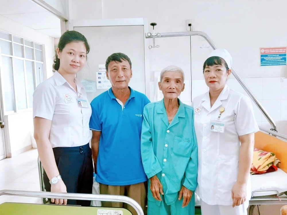 Ông Hoàng Thế Tuấn (thứ 2, bên phải) cùng người nhà và cán bộ Phòng Công tác xã hội bệnh viện Đa khoa tỉnh Khánh Hòa. (Ảnh: Phan Sáu/TTXVN)