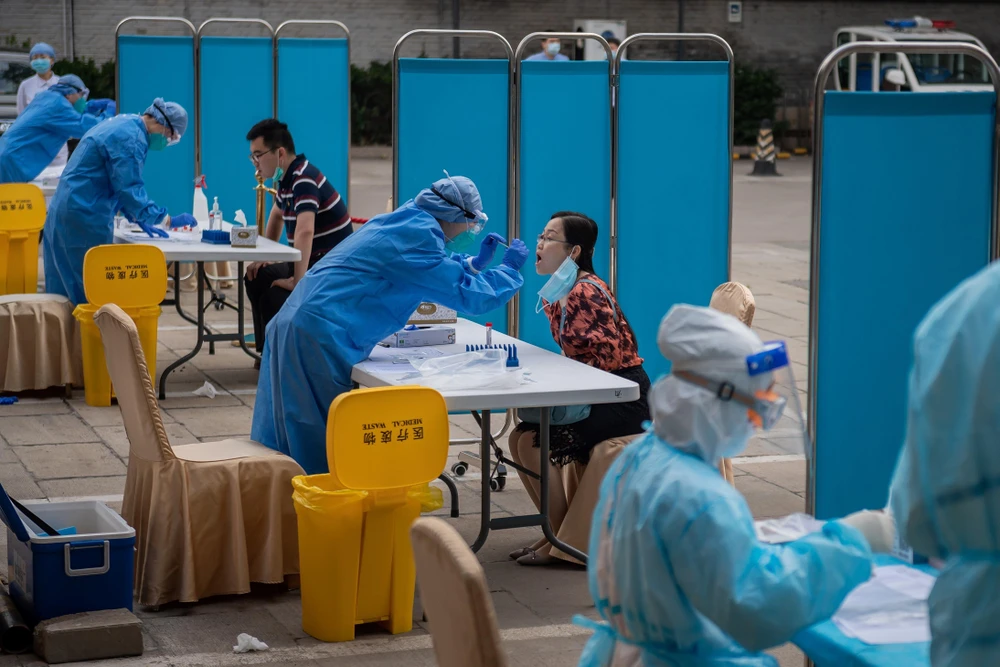 Nhân viên y tế lấy mẫu xét nghiệm COVID-19 cho người dân tại Bắc Kinh, Trung Quốc ngày 28/5/2020. (Ảnh: AFP/TTXVN)