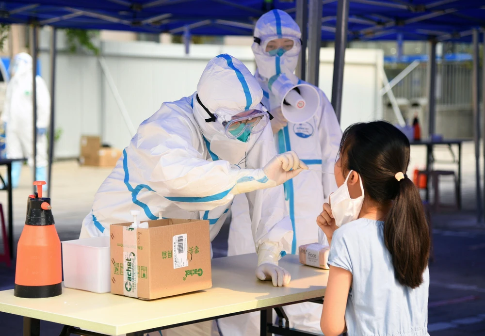 Nhân viên y tế lấy mẫu xét nghiệm COVID-19 cho người dân tại Bắc Kinh, Trung Quốc ngày 23/6/2020. (Ảnh: THX/TTXVN)