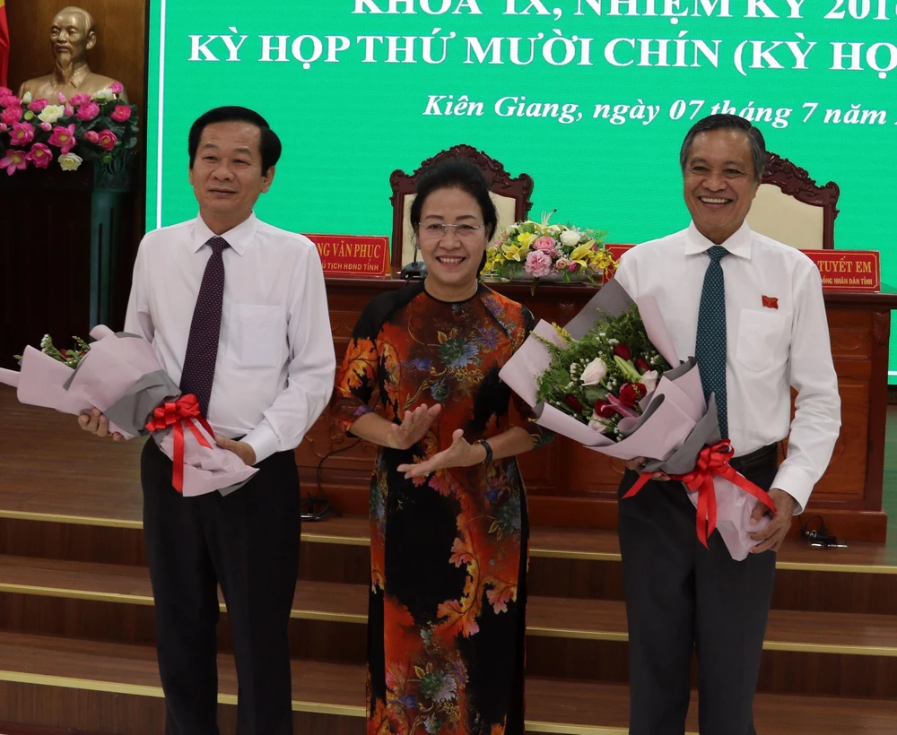 Tặng hoa chúc mừng tân Chủ tịch Đỗ Thanh Bình (trái) và nguyên Chủ tịch UBND tỉnh Phạm Vũ Hồng. (Ảnh: Lê Sen/TTXVN)