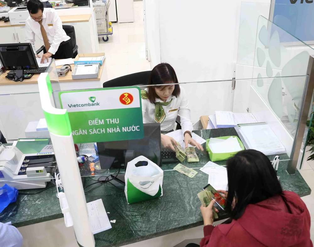 Người dân nộp thuế tại điểm thu Ngân hàng Vietcombank chi nhánh thành phố Cần Thơ. (Ảnh: Vũ Sinh/TTXVN)