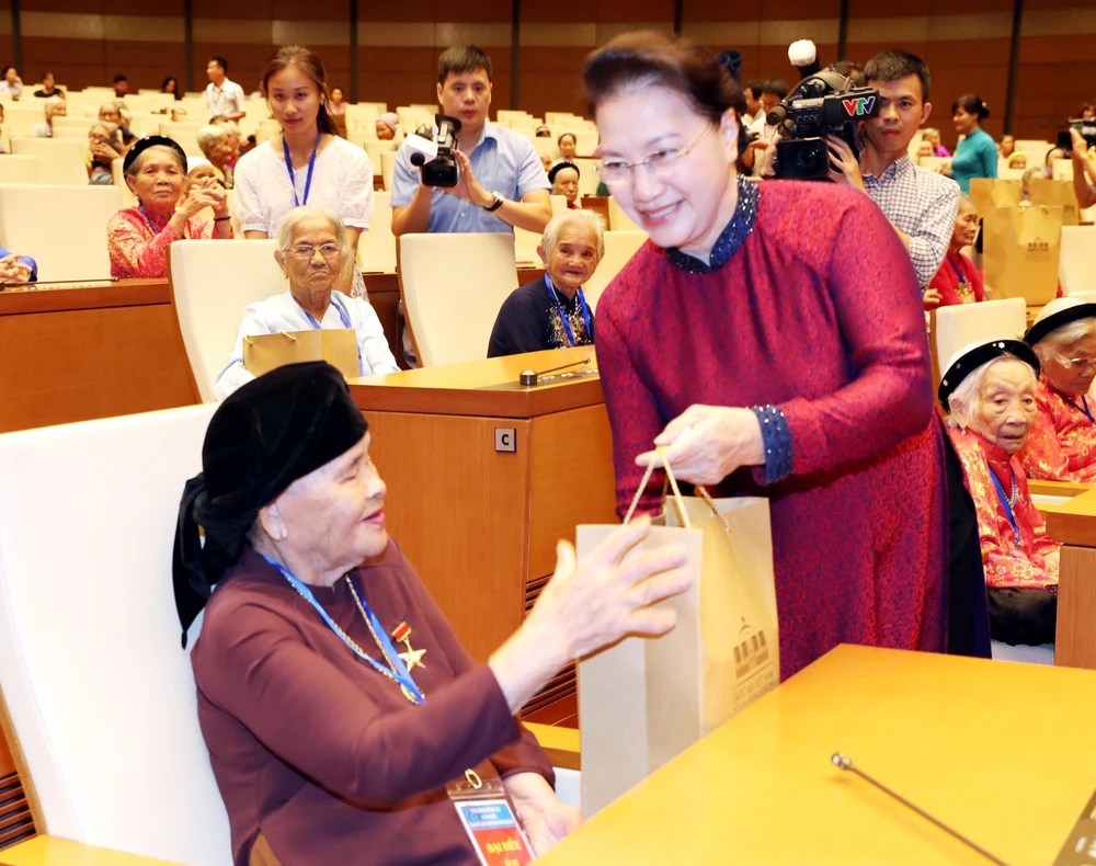 Chủ tịch Quốc hội Nguyễn Thị Kim Ngân tặng quà các Mẹ Việt Nam Anh hùng tại buổi gặp mặt. (Ảnh: Trọng Đức/TTXVN)