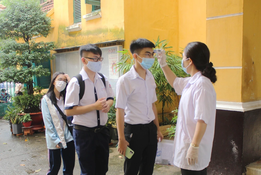 Hơn 75.000 thí sinh Thành phố Hồ Chí Minh đến làm thủ tục dự thi tốt nghiệp THPT đều được đo kiểm tra thân nhiệt. (Ảnh: Xuân Anh/TTXVN)