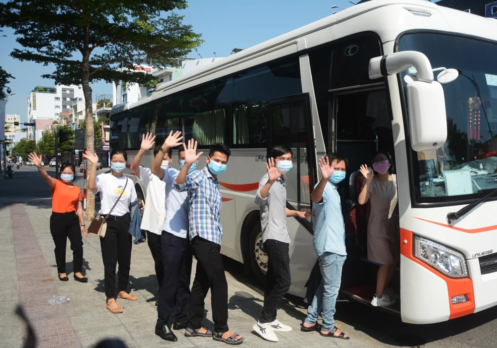 Các y, bác sỹ tỉnh Thừa Thiên Huế vẫy chào mọi người, sau khi hoàn thành nhiệm vụ hỗ trợ thành phố Đà Nẵng phòng, chống dịch. (Ảnh: Văn Dũng/TTXVN)