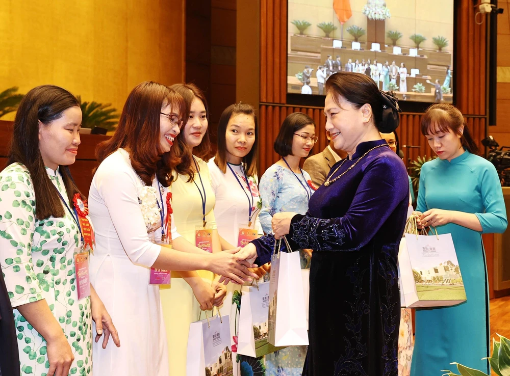 Chủ tịch Quốc hội Nguyễn Thị Kim Ngân tặng quà các giáo viên, nhà quản lý giáo dục tiêu biểu tại buổi gặp mặt. (Ảnh: Trọng Đức/TTXVN)