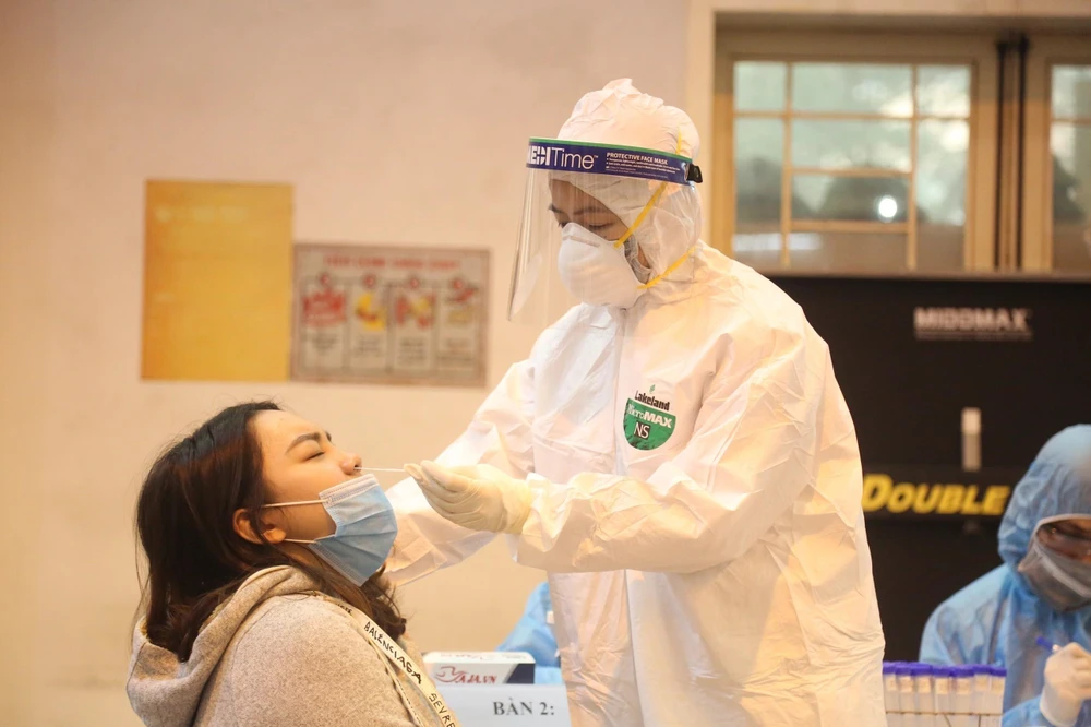 Nhân viên trung tâm Y tế quận Ba Đình, Hà Nội lấy mẫu dịch mũi xét nghiệm SARS-CoV-2 cho người dân trên địa bàn. (Ảnh TTXVN phát)
