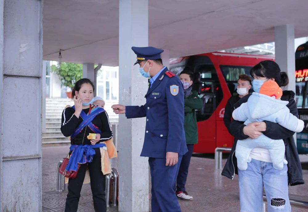 Lực lượng chức năng tuyên truyền nhắc nhở người dân đeo khẩu trang đúng cách tại bến xe khách Lai Châu để phòng chống dịch COVID - 19. (Ảnh: Quý Trung/TTXVN)