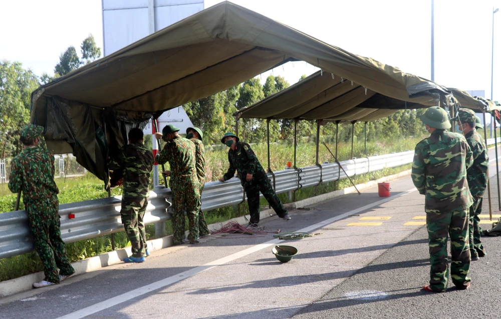 Ban chỉ huy Quân sự thị xã Quảng Yên đang dựng trạm kiểm soát lưu động tại chân cầu Bạch Đằng, trên cao tốc Quảng Ninh với Hải Phòng. (Ảnh: Văn Đức/TTXVN)