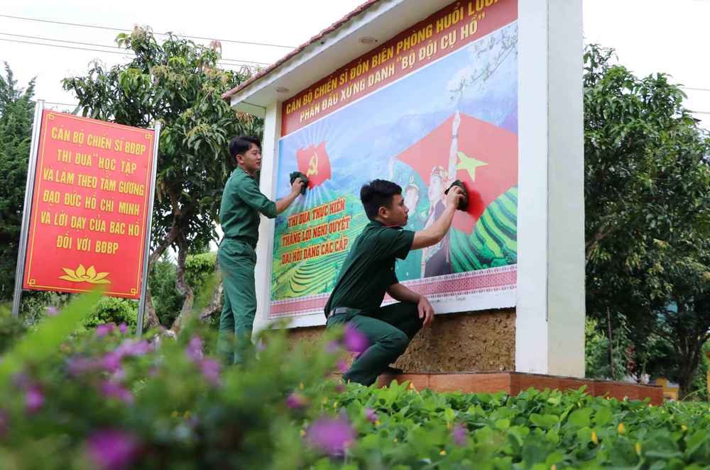 Các chiến sỹ Đồn Biên phòng Huổi Luông (Lai Châu) chỉnh trang lại bức cổ động bầu cử. (Ảnh: Nguyễn Oanh/TTXVN)