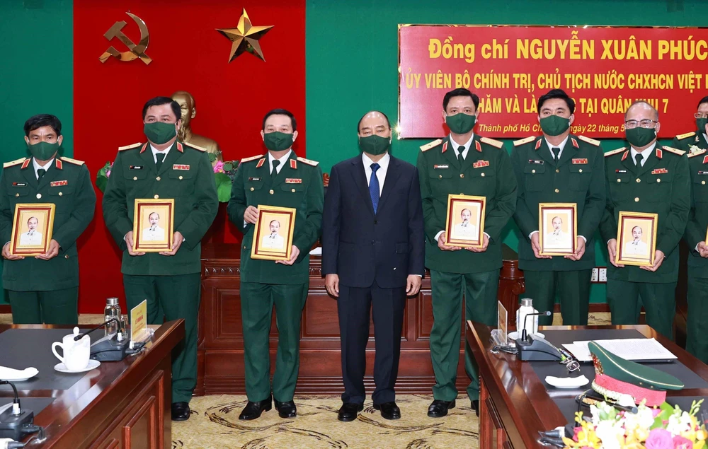 Chủ tịch nước Nguyễn Xuân Phúc tặng ảnh chân dung Chủ tịch Hồ Chí Minh cho cán bộ Bộ Tư lệnh Quân khu 7. (Ảnh: Thống Nhất/TTXVN)