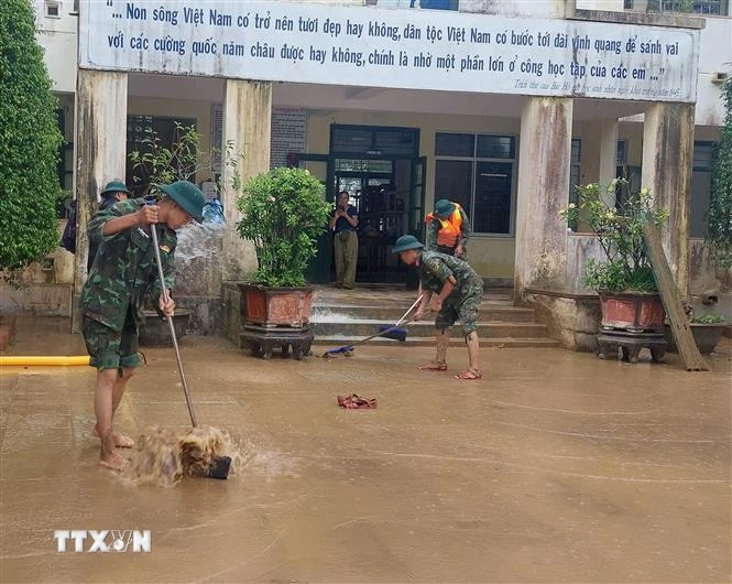 Lực lượng bộ đội hỗ trợ dọn bùn đất tại Trường Tiểu học và Trung học Cơ sở Cam Tuyền, huyện Cam Lộ (Quảng Trị). (Ảnh: TTXVN phát)