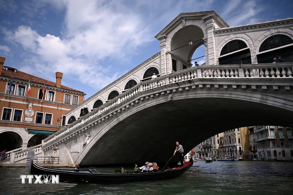 Khách du lịch đi thuyền gondola tại Venice, Italy. (Ảnh: AFP/TTXVN)