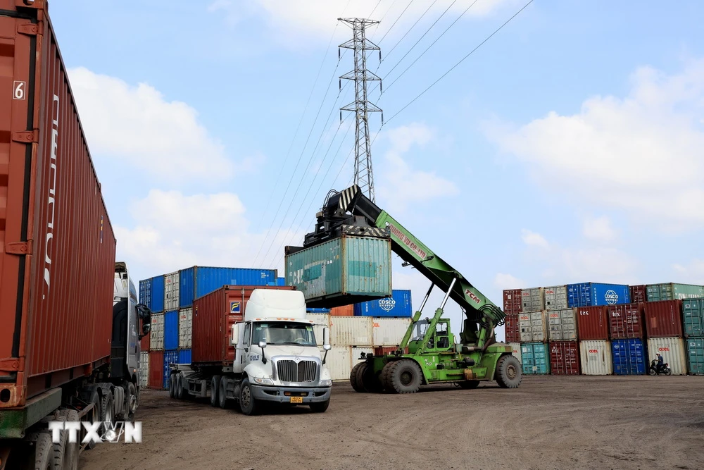 Bốc dỡ container gạo xuất khẩu đi Trung Quốc tại Cảng logistics Công ty TNHH Dương Vũ, huyện Thủ Thừa, Long An. (Ảnh: Hồng Đạt/TTXVN)