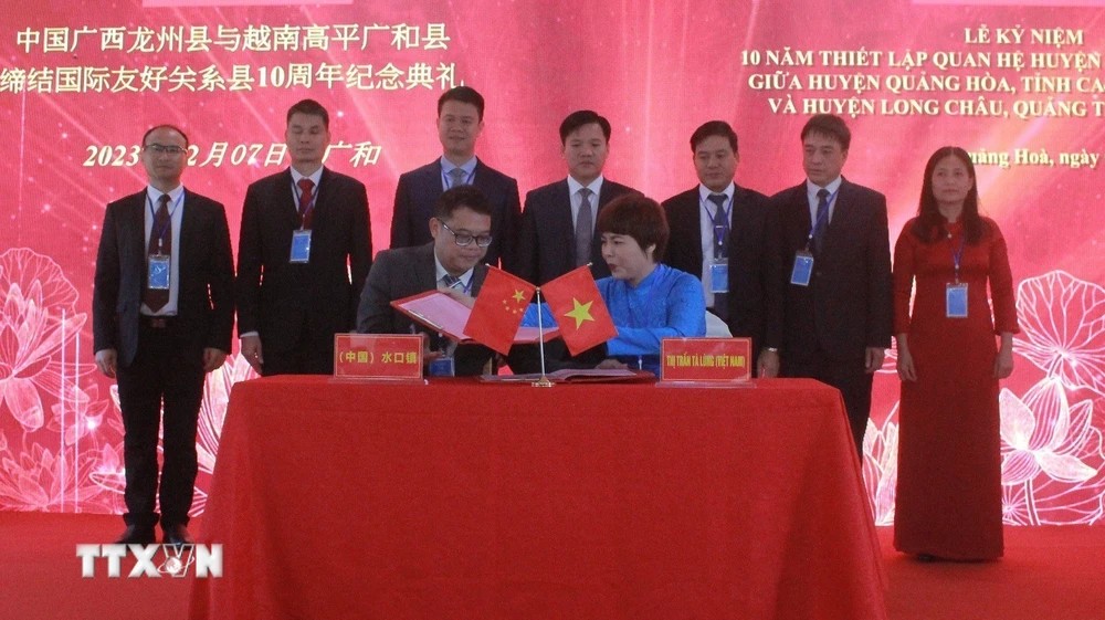 Đại diện Thị trấn Tà Lùng và Thị trấn Thủy Khẩu ký kết thỏa thuận hữu nghị hợp tác. (Ảnh: TTXVN phát)