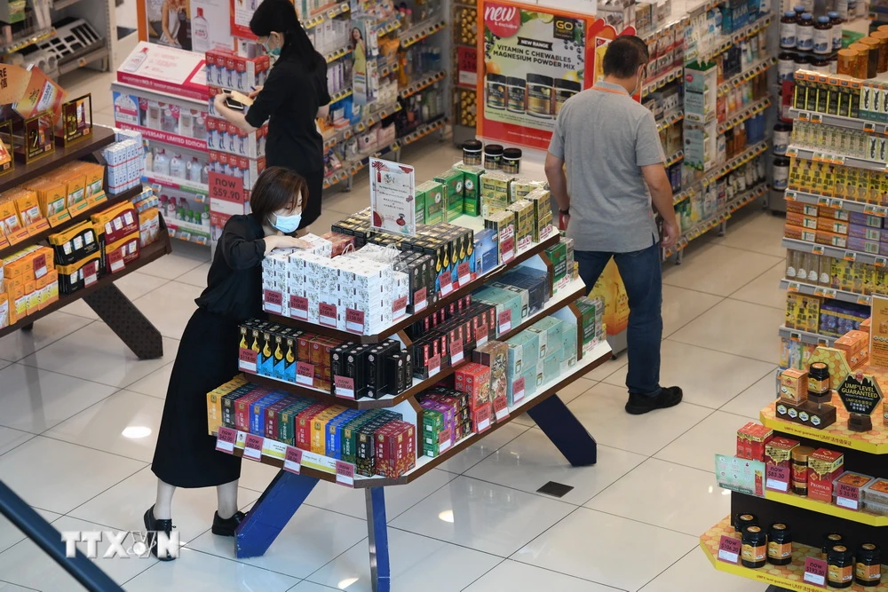 Người dân mua hàng trong siêu thị ở Singapore. (Ảnh: AFP/TTXVN)
