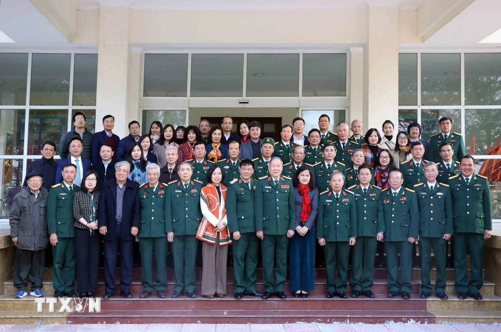 Đoàn đại biểu Thông tấn xã Việt Nam và đại biểu Sư đoàn 304 chụp ảnh lưu niệm. (Ảnh: An Đăng/TTXVN)