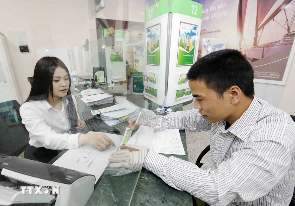 Khách hàng giao dịch tại Vietcombank Hà Nội. (Ảnh: Trần Việt/TTXVN)