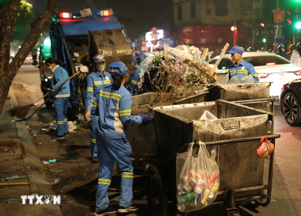 Những công nhân Công ty TNHH Môi trường đô thị Hà Nội (URENCO) - Chi nhánh Hoàn Kiếm vẫn miệt mài làm việc khi gần đến thời điểm đón Giao thừa Tết Quý Mão 2023. (Ảnh: Hoàng Hiếu/TTXVN)