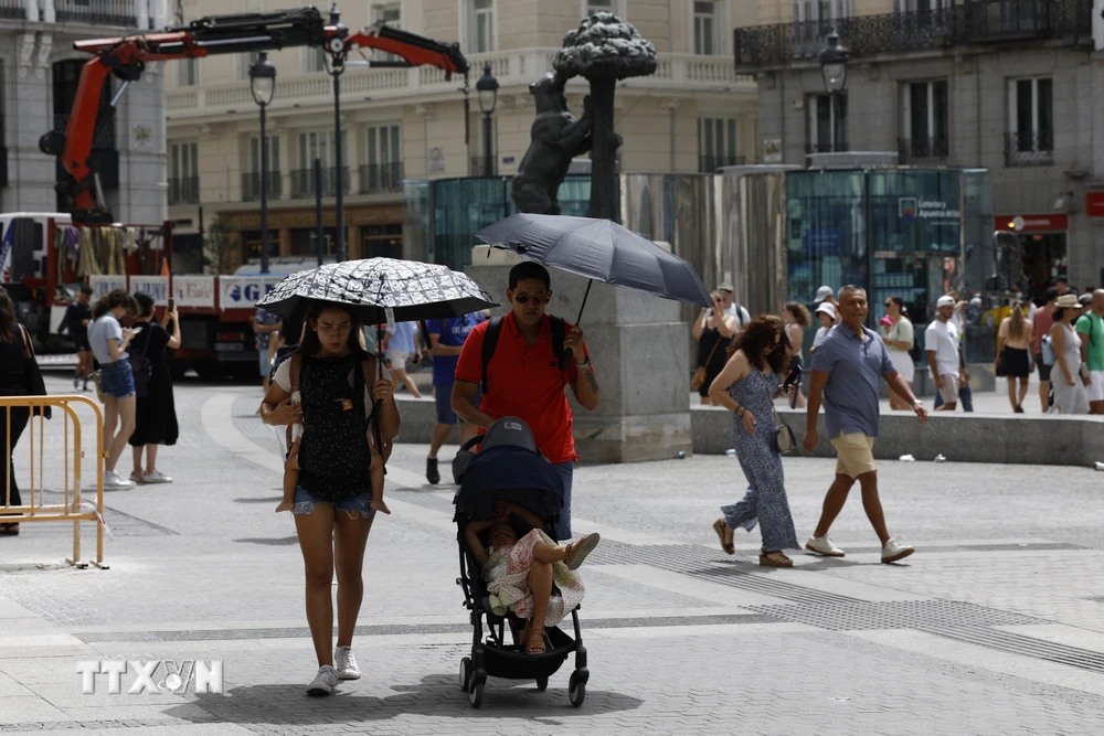 Người dân di chuyển dưới trời nắng nóng tại Madrid, Tây Ban Nha, ngày 9/8/2023. (Ảnh: AFP/TTXVN)