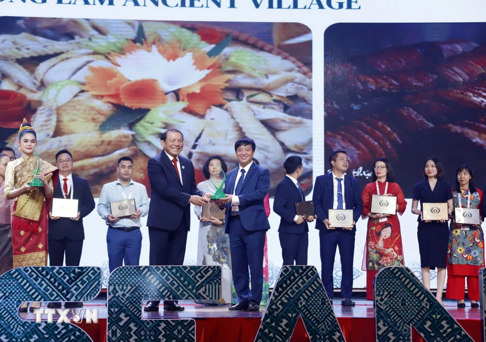 Bộ trưởng Bộ Văn hóa-Thể thao và Du lịch Việt Nam Nguyễn Văn Hùng trao Giải thưởng Du lịch ASEAN 2024 cho đại diện Làng cổ Đường Lâm. (Ảnh: Phạm Kiên/TTXVN)