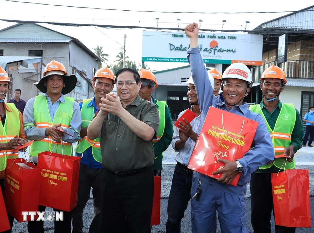 Thủ tướng Phạm Minh Chính tặng quà, động viên công nhân đang thi công tuyến đê kè ứng phó biến đổi khí hậu tại sông Cần Thơ, thuộc Dự án phát triển thành phố Cần Thơ. (Ảnh: Văn Điệp/TTXVN)