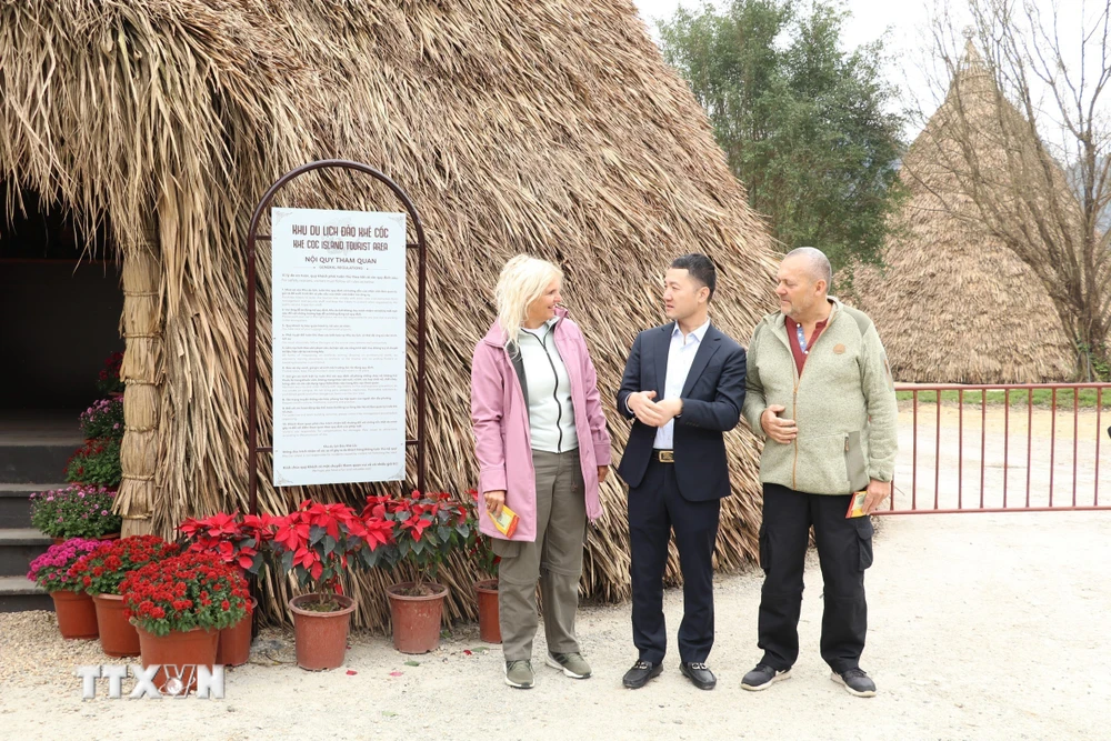Giám đốc Sở Du lịch tỉnh Ninh Bình giới thiệu về văn hóa Tết cổ truyền của Việt Nam vào sáng mùng 1 Tết với 2 du khách đến từ Đan Mạnh. (Ảnh: Đức Phương/TTXVN)