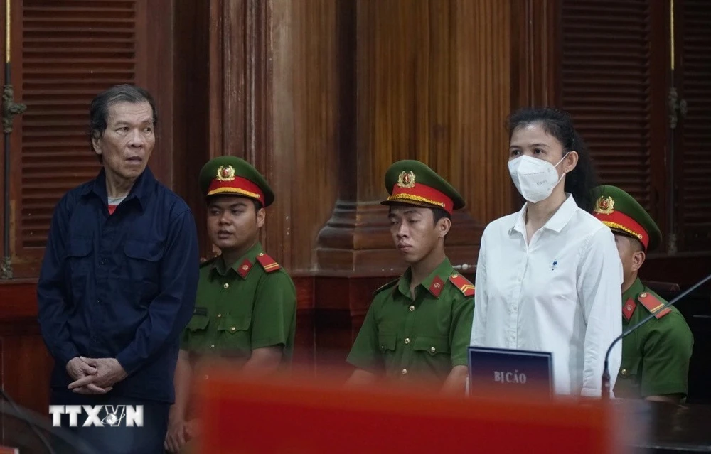Hai bị cáo Trần Văn Sỹ (trái) và bị cáo Đặng Thị Hàn Ni (phải) đứng nghe tuyên án. (Ảnh: Hồng Giang/TTXVN)