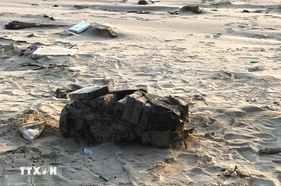 Túi màu đen chứa 20 bánh tinh thể màu trắng nghi ma túy trên bờ biển được phát hiện vào sáng nay 6/3. (Ảnh TTXVN phát)