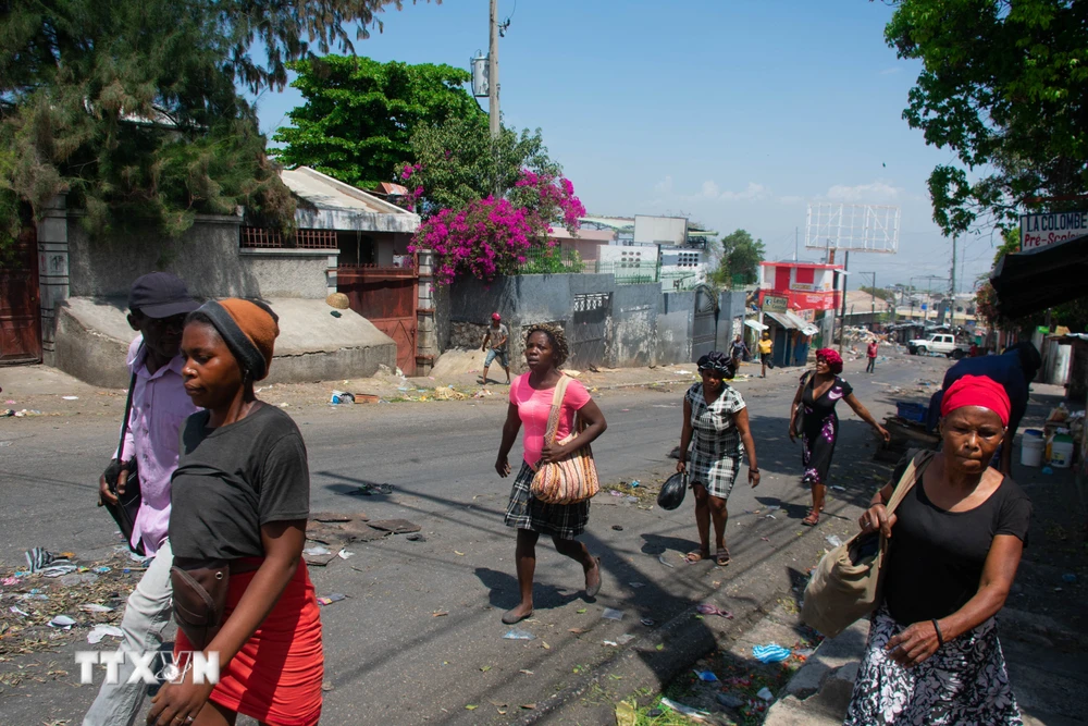 Người dân chạy trốn khỏi khu vực xảy ra đụng độ ở Port-au-Prince, Haiti ngày 20/3/2024. (Ảnh: AFP/TTXVN)