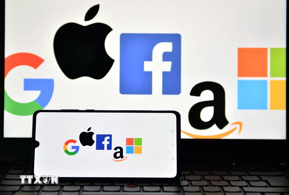 Biểu tượng của Google, Apple, Facebook, Amazon và Microsoft trên màn hình điện thoại và máy tính bảng. (Ảnh: AFP/TTXVN)