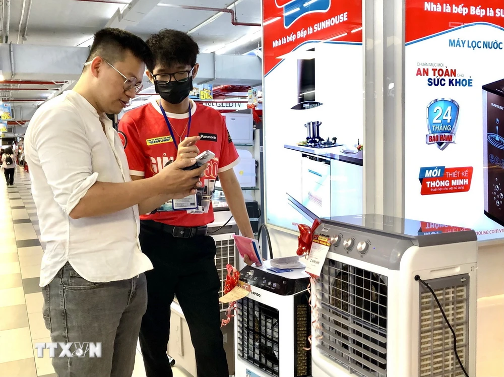 Nhân viên bán hàng giới thiệu sản phẩm quạt lạnh đến người tiêu dùng Thành phố Hồ Chí Minh. (Ảnh: Mỹ Phương/TTXVN)