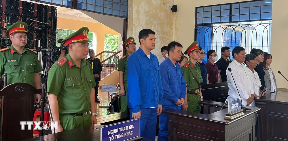 Bị cáo Lê Dương (áo xanh bên trái) và bị cáo Hoàng Văn Tính (áo xanh bên phải) trước tòa. (Ảnh: Sỹ Tuyên/TTXVN)
