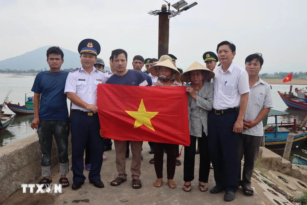 Hải đội 102 - Bộ Tư lệnh vùng Cảnh sát biển 1 trao tặng cờ Tổ quốc cho ngư dân Cẩm Nhượng, huyện Cẩm Xuyên. (Ảnh: Hoàng Ngà/TTXVN)