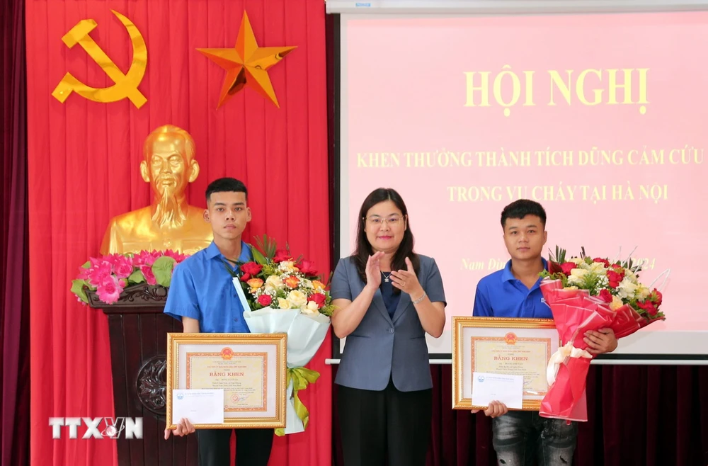 Lãnh đạo UBND tỉnh Nam Định trao Bằng khen cho 2 thanh niên dũng cảm cứu người trong vụ cháy rạng sáng 24/5 tại Hà Nội. (Ảnh: Nguyễn Lành/TTXVN)