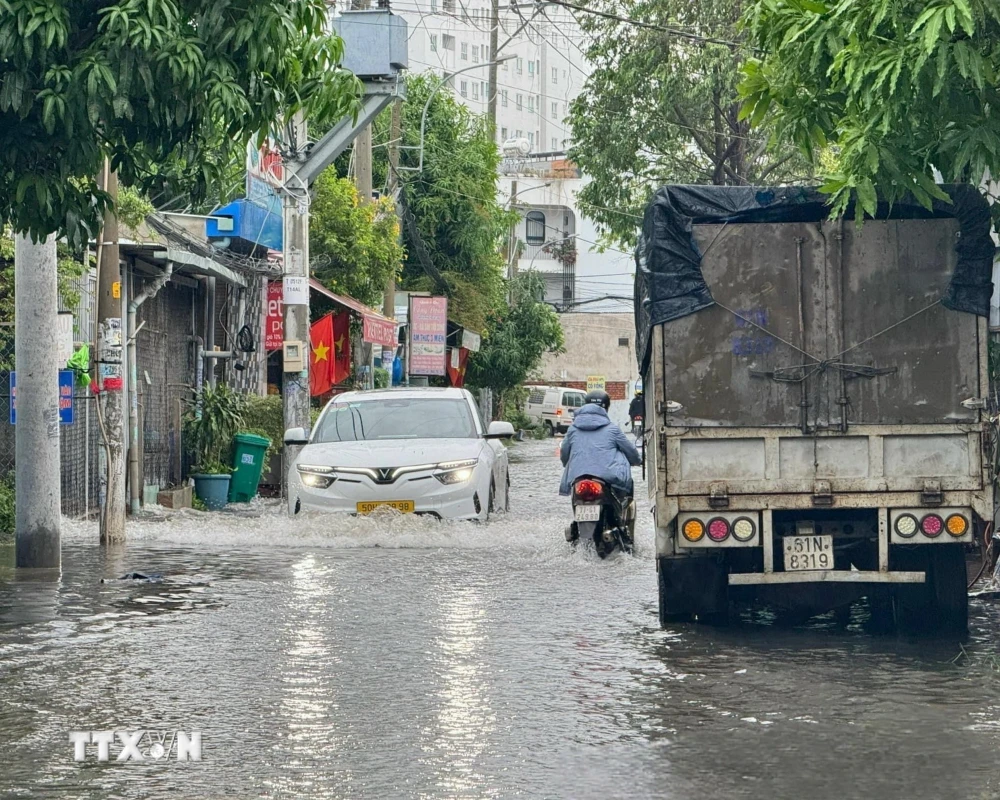 Nước ngập gần hết bánh xe mô tô trên Đường 12 (thành phố Thủ Đức, Thành phố Hồ Chí Minh). (Ảnh minh họa: Hồng Giang/TTXVN)