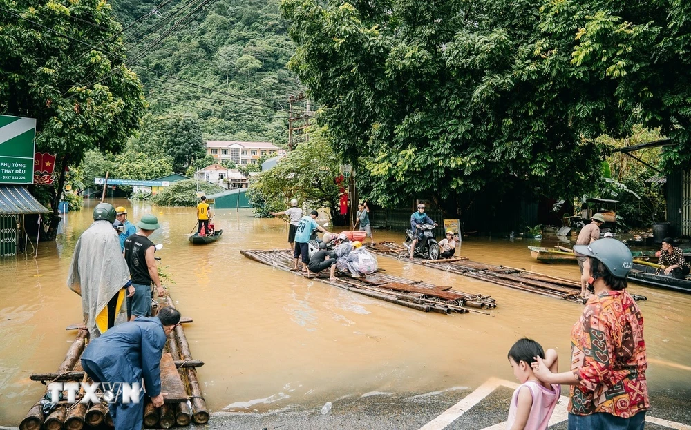 Tuyến đường thuộc thị trấn Pác Mjầu, huyện Bảo Lâm bị ngập sâu, người dân phải dùng bè mảng để di chuyển. (Ảnh: Bảo Chung/TTXVN phát)